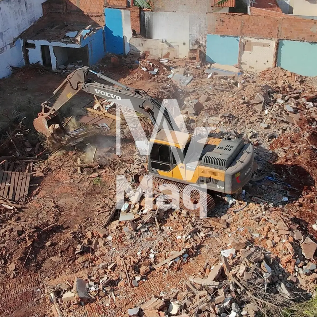 Escavadeira Volvo em demolição de casa com entulho no terreno