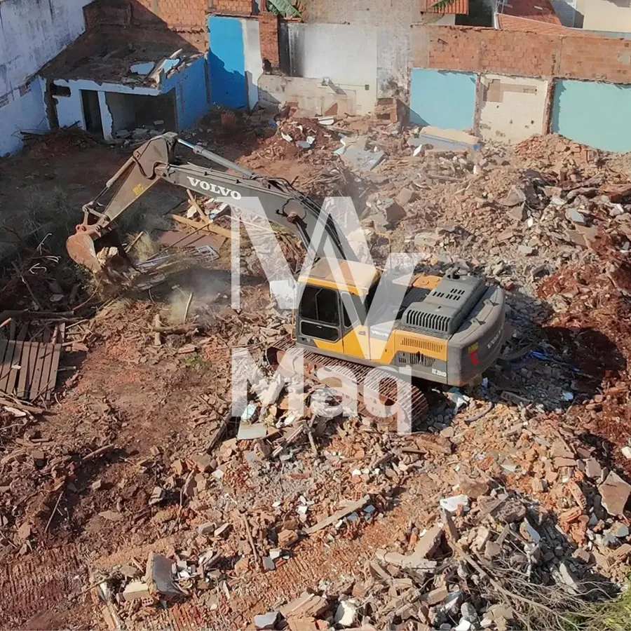 Escavadeira Volvo em demolição de casa com entulho no terreno