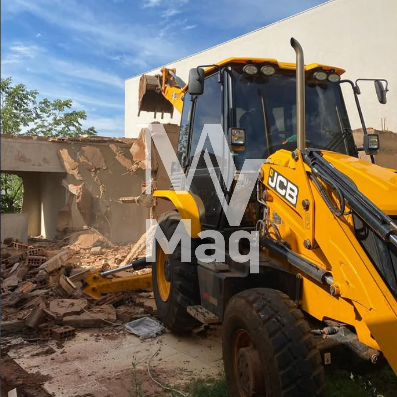 Retroescavadeira JCB demolindo parede de alvenaria